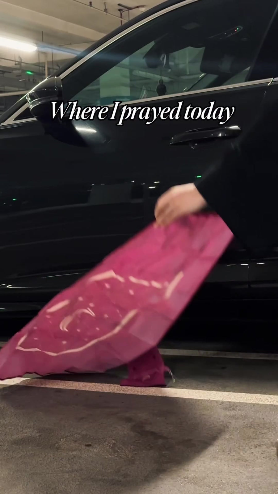 Unfolding a pink prayer mat beside the car